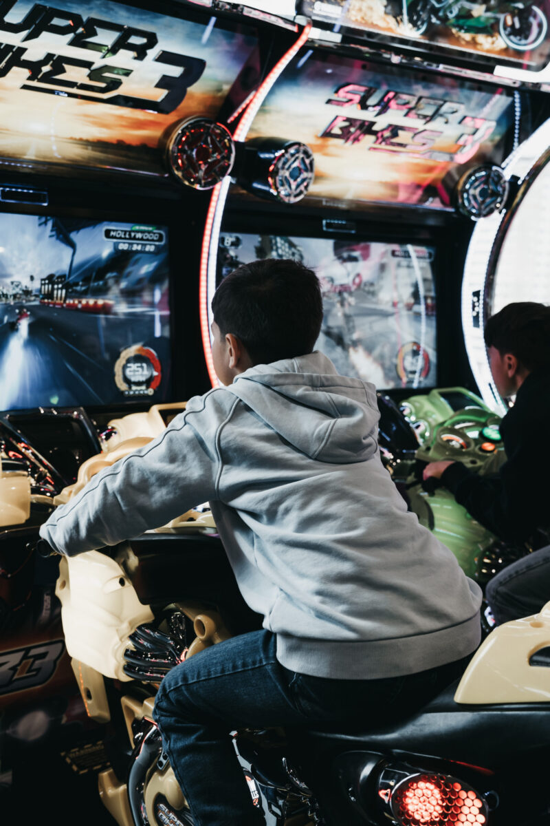 Boy on the Super Bikes arcade game in Antwerp – Jongen op het Super Bikes-arcadespel in Antwerpen